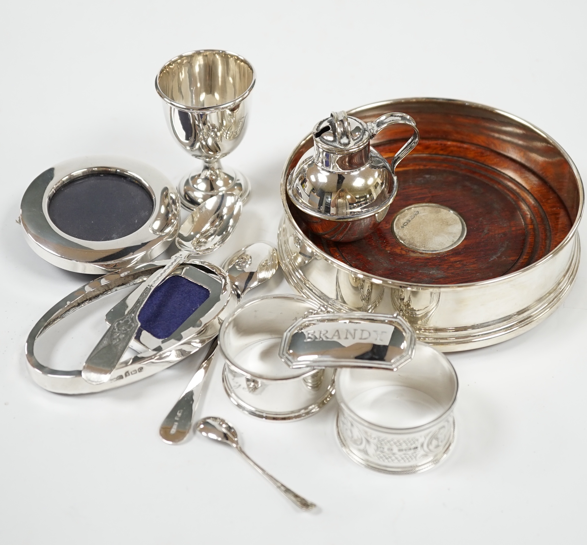A modern silver mounted wine label and a quantity of sundry small silver including wine labels, small photograph frames, napkin rings, flatware etc. and a plated Guernsey milk can condiment. Condition - fair to good